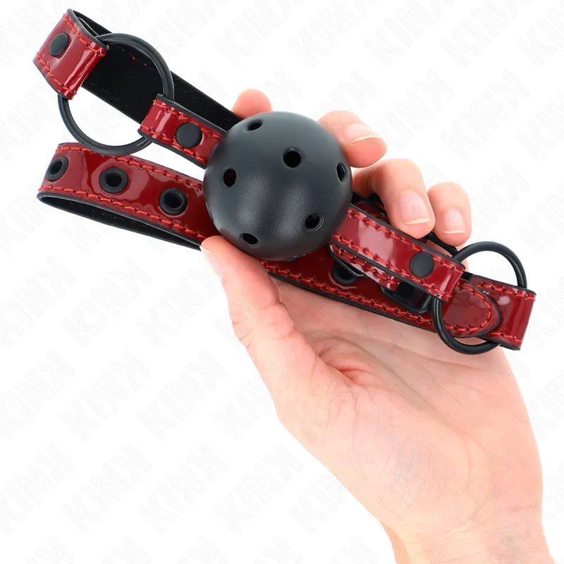 Gag BDSM en silicone noir avec sangle rouge ajustable, design ergonomique et hypoallergénique pour confort et sécurité.