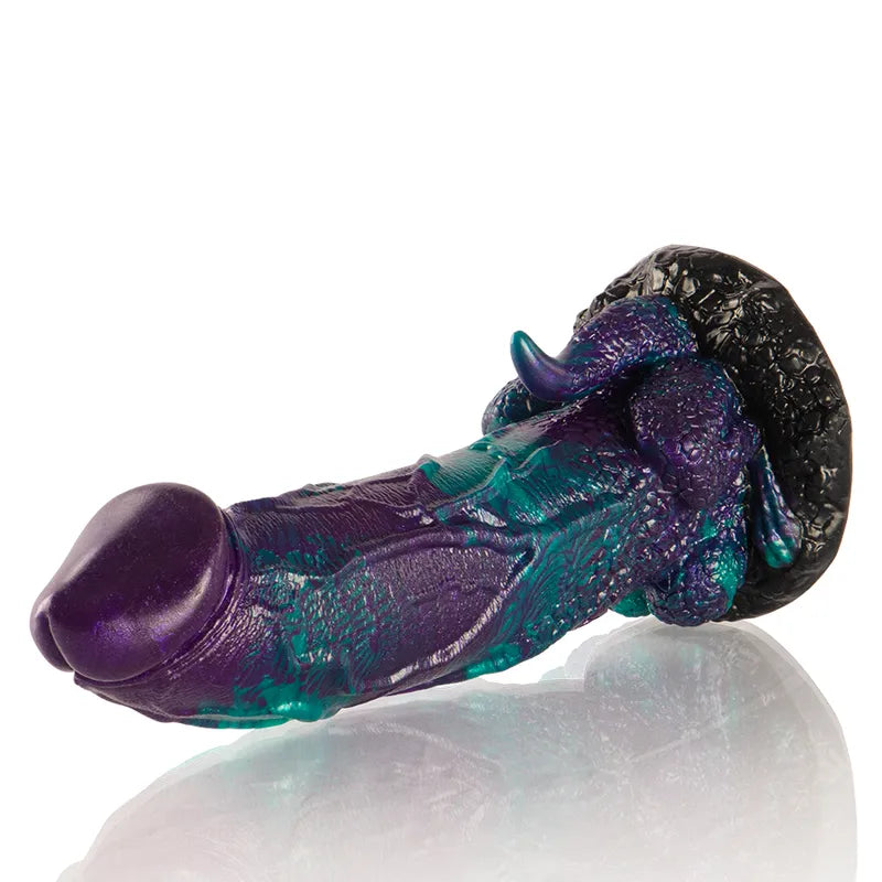 Gode en silicone Basilisk, teintes violettes et vertes, texture sculptée réaliste, inspiré de la mythologie grecque.