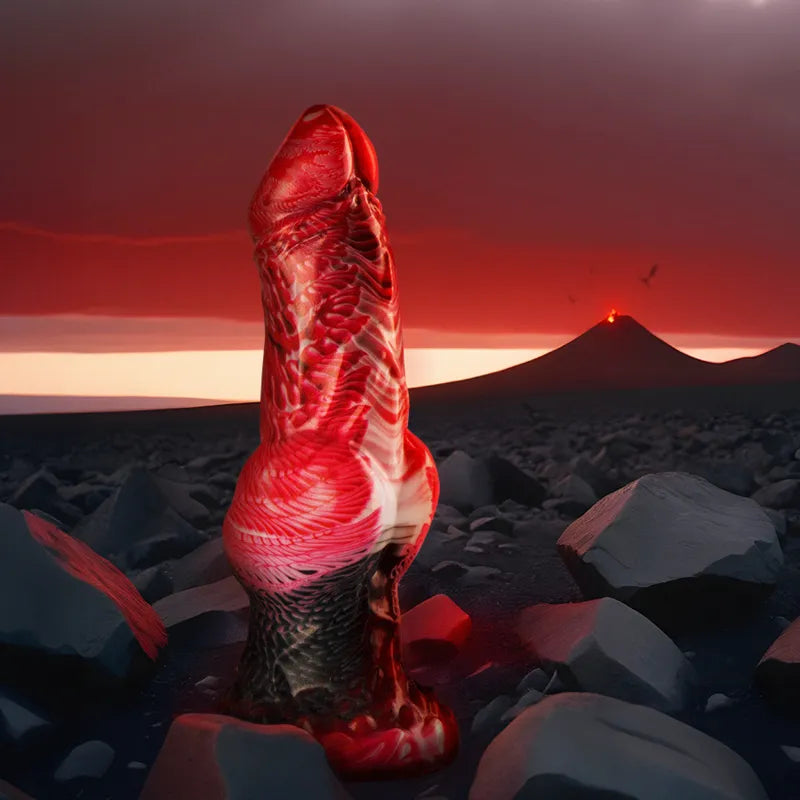 Gode silicone rouge texturé, courbes inspirées mythologie grecque, posé sur fond volcanique dramatique.