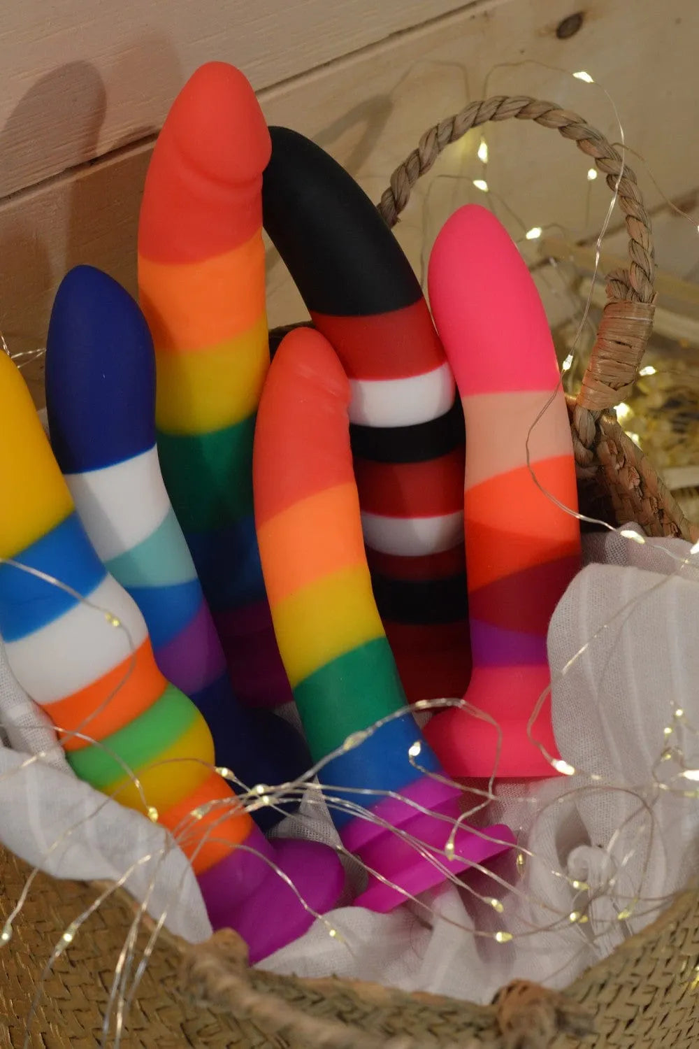 Godes en silicone colorés avec ventouse, hypoallergéniques, pour usage anal et vaginal, fixables sur harnais, dans un panier.
