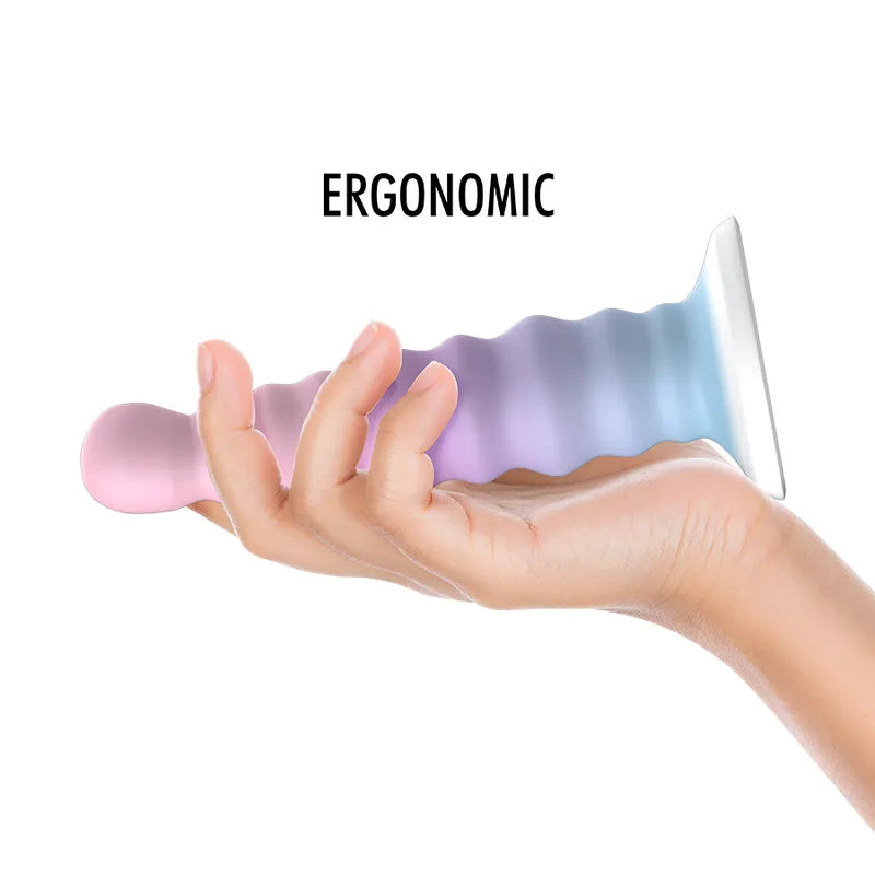 Gode silicone Nayade pastel ergonomique, base aspirante, flexible, hypoallergénique, compatible harnais, main tenant.