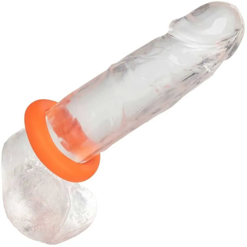 Anneau pénien en silicone liquide orange, extensible et étanche, sur un support transparent, idéal pour douche et bain.