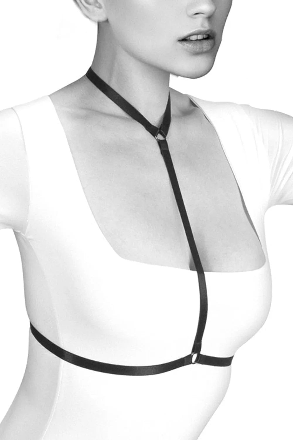 Harnais noir femme Pamela, élastique et réglable, style BDSM, porté sur une tenue blanche, élégant et audacieux.