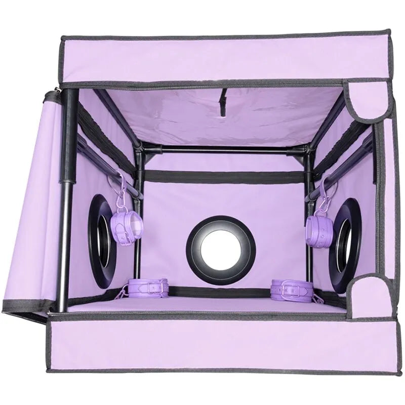 Cabine intime violette compacte avec lumière LED, matelas intégré, accessoires discrets pour jeux de rôle et soumission.