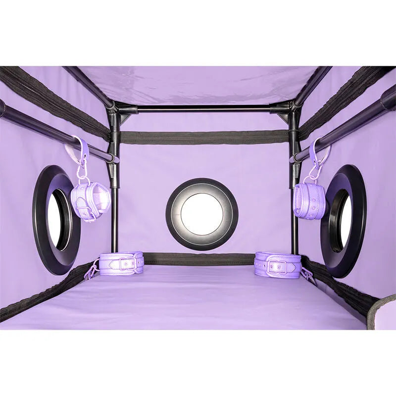 Cabine intime violette avec LED, structure robuste, matelas intégré, accessoires discrets pour jeux de rôle et soumission.