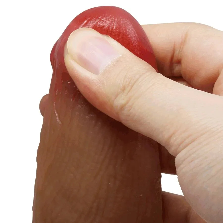 Gode silicone réaliste marron avec tête rouge bulbeuse, veinures détaillées, tenu par une main, stimulation interne.