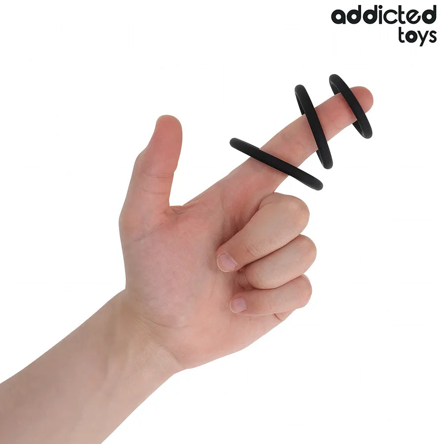 Anneaux péniens en silicone noir, trois tailles ajustables, sur une main, pour stimulation et performance améliorée.