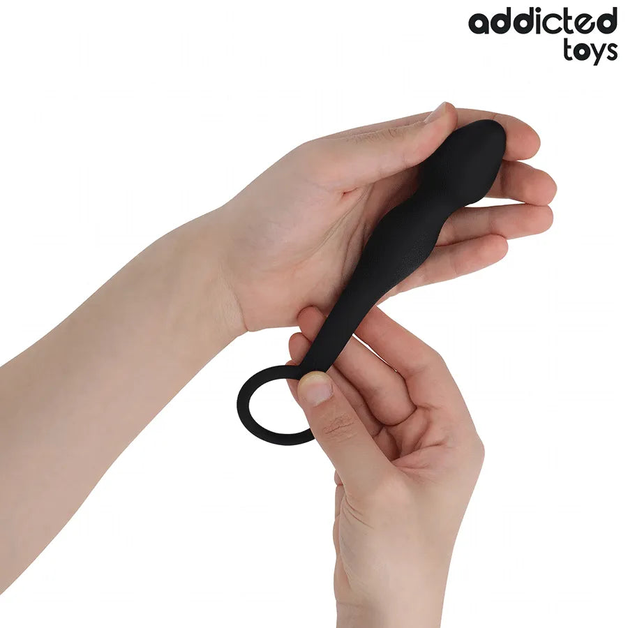 Plug anal noir en silicone médical avec anneau, design ergonomique, tenu dans une main pour stimulation prostatique.