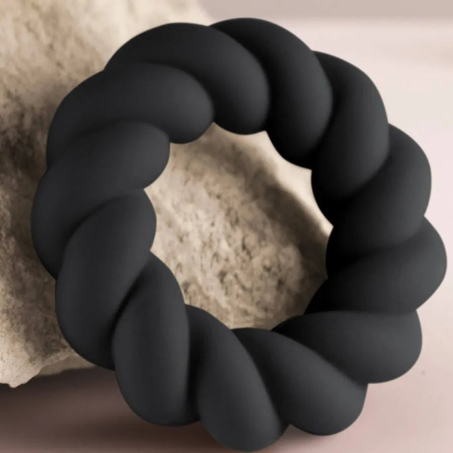 Anneau pénien noir en silicone, ergonomique et étanche, design torsadé pour stimulation et prolongation du plaisir.
