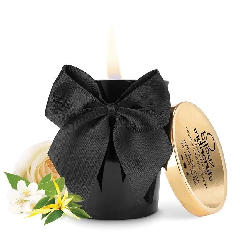 Bougie de massage noire avec nœud noir, couvercle doré, parfum rose ylang-ylang jasmin, ambiance romantique.